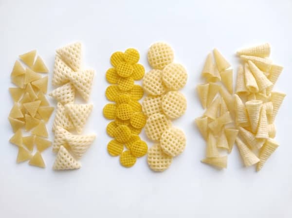 Punched and sheet-cut snack pellets like lattice chips and 3D triangles.