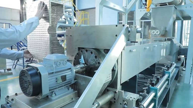Engineer performing screw-to-barrel clearance measurement and wear inspection on twin screw extruder barrel liners.